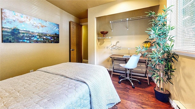 23301 Cedar Way Unit U102, Mountlake Terrace, WA 98043 - bedroom featuring a baseboard radiator, wood finished floors, a desk, and a closet