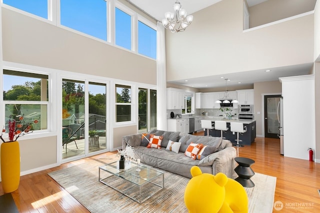 8441 8th Ave SW, Seattle, WA 98106 - living room featuring a towering ceiling, light wood finished floors, a chandelier, and plenty of natural light