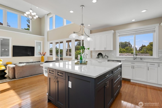 8441 8th Ave SW, Seattle, WA 98106 - kitchen featuring white cabinetry, healthy amount of natural light, decorative backsplash, decorative light fixtures, and a high ceiling