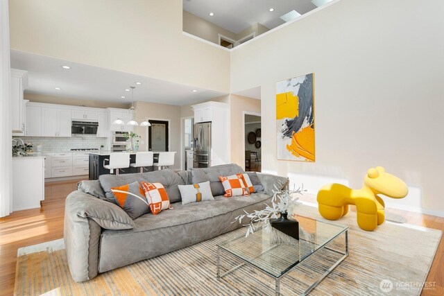 8441 8th Ave SW, Seattle, WA 98106 - living room featuring light wood-type flooring, recessed lighting, and a towering ceiling