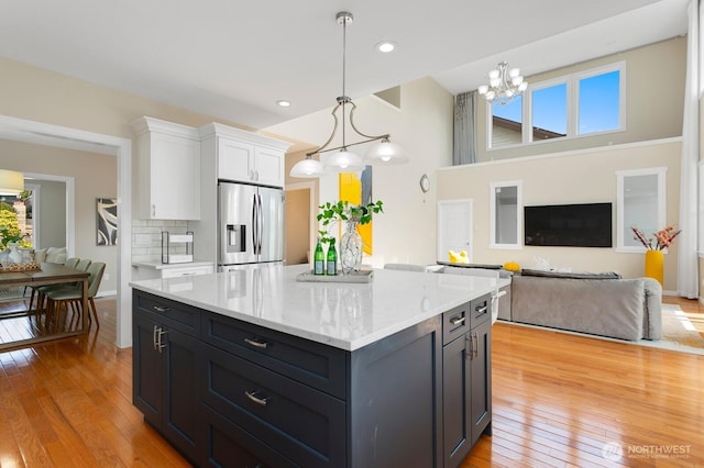 8441 8th Ave SW, Seattle, WA 98106 - kitchen with stainless steel fridge with ice dispenser, white cabinets, light wood-type flooring, open floor plan, and recessed lighting