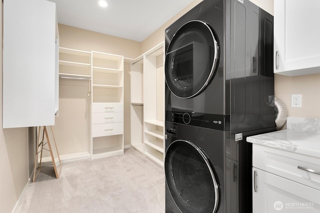 8441 8th Ave SW, Seattle, WA 98106 - laundry room with stacked washer and clothes dryer, cabinet space, and light carpet