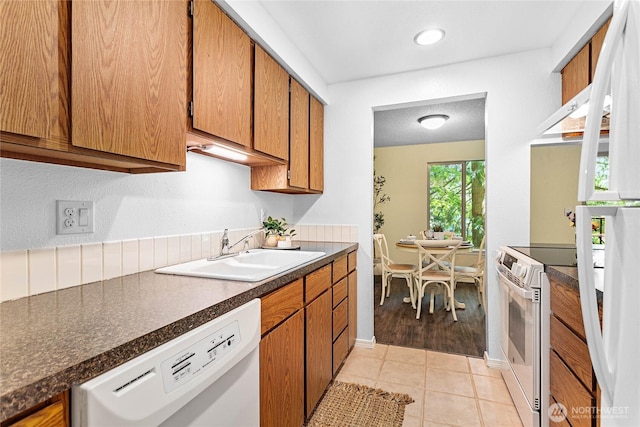 3100 Bill Mcdonald Pkwy Unit E101, Bellingham, WA 98225 - kitchen featuring white appliances, brown cabinetry, dark countertops, and light tile patterned floors