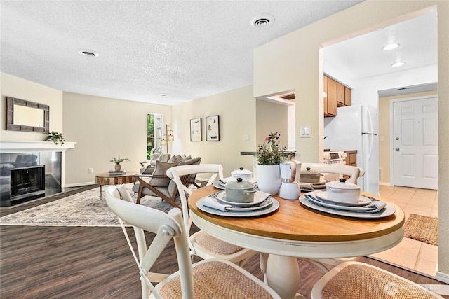 3100 Bill Mcdonald Pkwy Unit E101, Bellingham, WA 98225 - dining space featuring a tile fireplace, a textured ceiling, recessed lighting, and wood finished floors