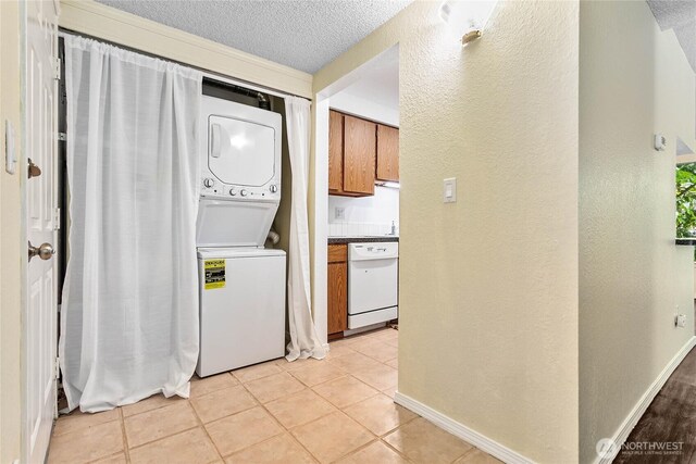 3100 Bill Mcdonald Pkwy Unit E101, Bellingham, WA 98225 - laundry area with estacked washer and dryer, light tile patterned floors, a textured ceiling, and a textured wall