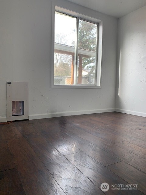 9928 Yakima Ave S, Tacoma, WA 98444 - unfurnished living room with dark wood finished floors and baseboards