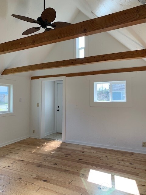 9928 Yakima Ave S, Tacoma, WA 98444 - unfurnished room featuring beamed ceiling, plenty of natural light, light wood-type flooring, ceiling fan, and high vaulted ceiling