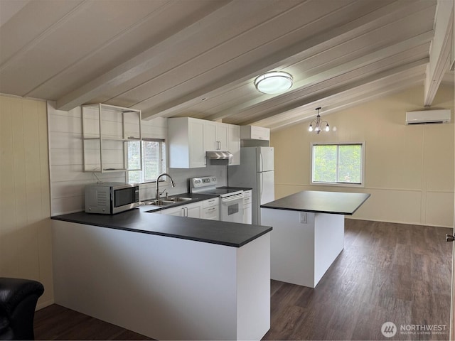 31 House Rd, Sequim, WA 98382 - kitchen featuring white appliances, dark countertops, under cabinet range hood, and plenty of natural light