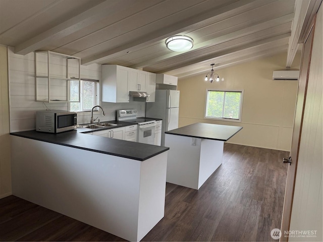 31 House Rd, Sequim, WA 98382 - kitchen with white appliances, dark countertops, a peninsula, dark wood-style floors, and an AC wall unit