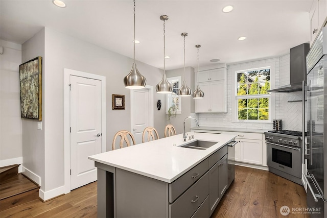 901 W Mcgraw St Unit 6, Seattle, WA 98119 - kitchen featuring appliances with stainless steel finishes, wall chimney range hood, backsplash, light countertops, and white cabinets