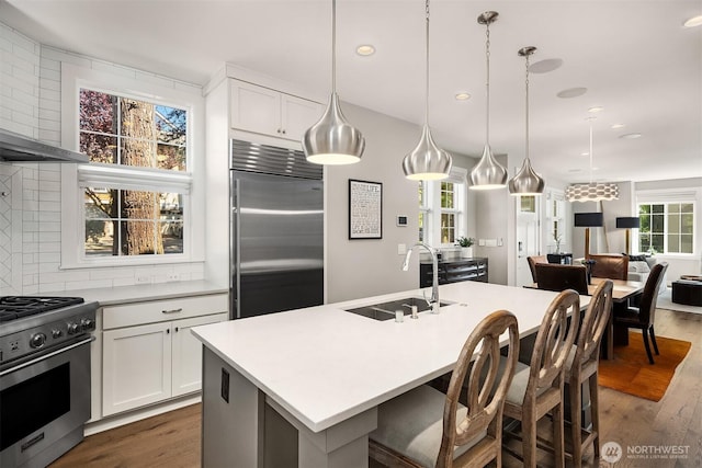 901 W Mcgraw St Unit 6, Seattle, WA 98119 - kitchen featuring high end appliances, dark wood finished floors, light countertops, a kitchen breakfast bar, and recessed lighting