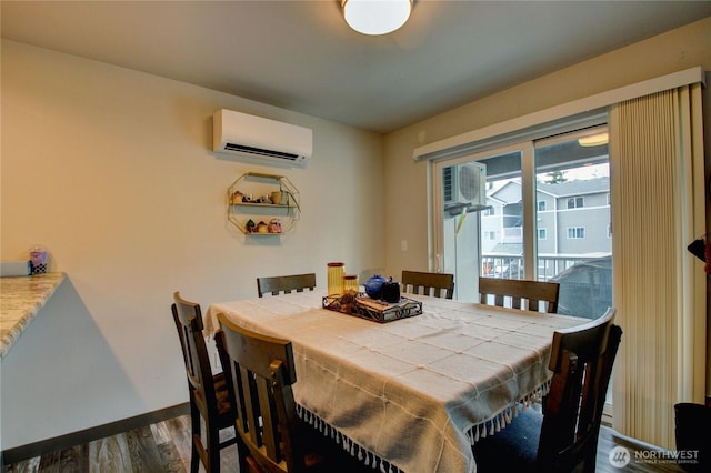 1651SW Mulberry St Unit E304, Oak Harbor, WA 98277 - dining space featuring a wall unit AC, dark wood-style flooring, and a wall mounted air conditioner