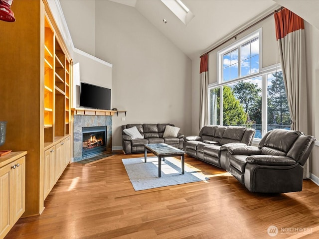 2135 204th Pl NE, Sammamish, WA 98074 - living area featuring high vaulted ceiling, a tile fireplace, light wood-style flooring, and a skylight