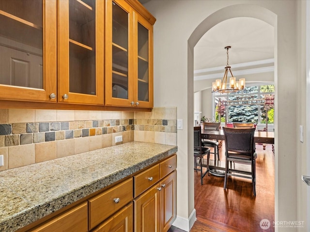 2135 204th Pl NE, Sammamish, WA 98074 - kitchen with a chandelier, brown cabinets, glass insert cabinets, decorative backsplash, and dark wood-style floors