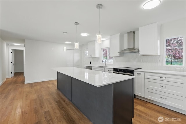 40 E Robert Pl, Sequim, WA 98382 - kitchen with wall chimney exhaust hood, a center island, white cabinetry, light countertops, and wood finished floors