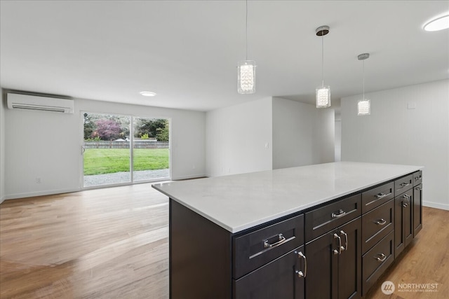 40 E Robert Pl, Sequim, WA 98382 - kitchen featuring an AC wall unit, light wood finished floors, light countertops, and hanging light fixtures