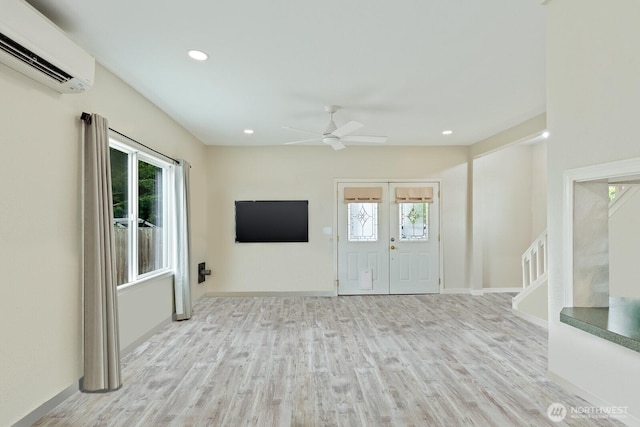 27902 69th Ave NW, Stanwood, WA 98292 - unfurnished living room featuring a wall unit AC, ceiling fan, wood finished floors, stairway, and recessed lighting