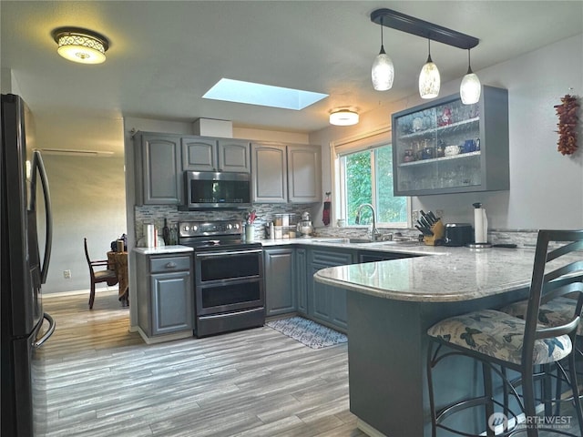 4313 131st St SE, Everett, WA 98208 - kitchen with stainless steel appliances, gray cabinetry, a peninsula, and a breakfast bar