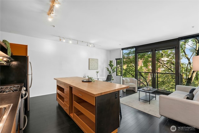 1111 E Pike St Unit 302, Seattle, WA 98122 - kitchen featuring butcher block counters, track lighting, stainless steel gas stove, open floor plan, and floor to ceiling windows