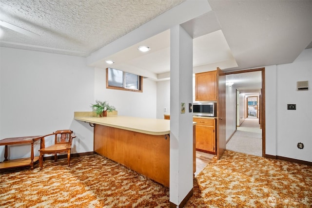 14000 NE 97th Ave, Vancouver, WA 98662 - kitchen with stainless steel microwave, a peninsula, light colored carpet, light countertops, and a textured ceiling
