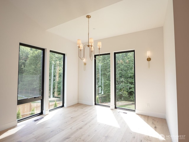 24018 Dolphin Ln, Mount Vernon, WA 98274 - empty room featuring plenty of natural light, wood finished floors, and a chandelier