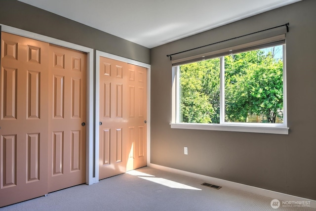 4138 21st Ave SW, Seattle, WA 98106 - unfurnished bedroom with multiple closets and carpet flooring