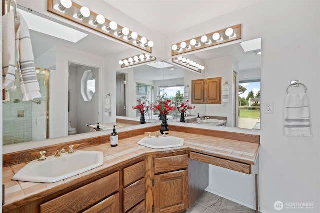 19724 Island Pkwy E, Lake Tapps, WA 98391 - bathroom with a skylight, double vanity, and a stall shower