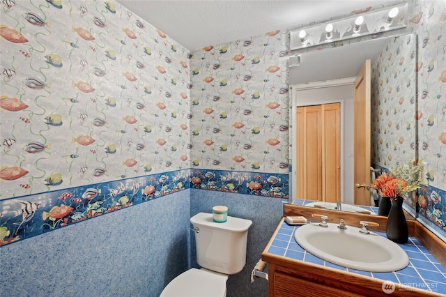 19724 Island Pkwy E, Lake Tapps, WA 98391 - half bathroom with wallpapered walls, vanity, and a textured ceiling