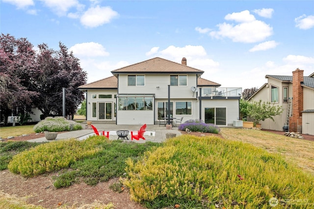 19724 Island Pkwy E, Lake Tapps, WA 98391 - back of property with a chimney, a patio area, an outdoor fire pit, a balcony, and a tiled roof