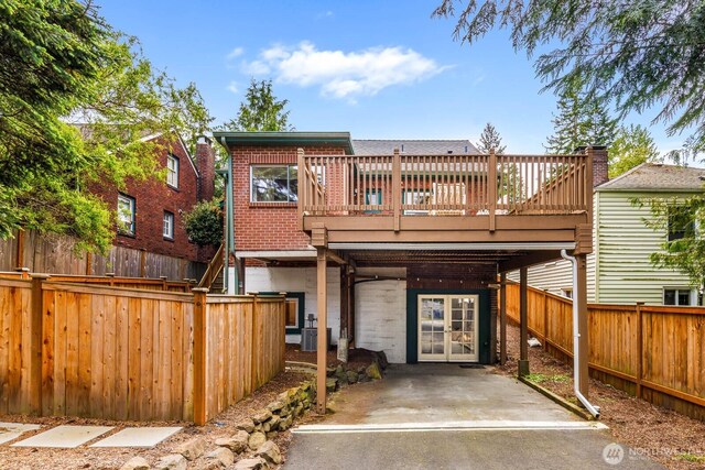 1214 NE 98th St, Seattle, WA 98115 - back of house with a deck, french doors, a fenced backyard, and brick siding
