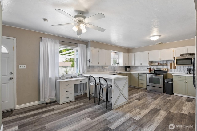 863 N Vista Dr, Moses Lake, WA 98837 - kitchen with appliances with stainless steel finishes, a peninsula, dark wood-style floors, and healthy amount of natural light