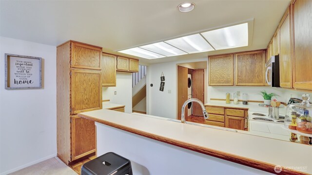 16159 SE 33rd Cir Unit 603, Bellevue, WA 98008 - kitchen featuring light countertops, a peninsula, recessed lighting, and stacked washer / dryer