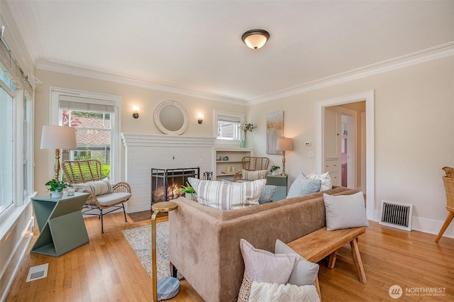 515 N 122nd St, Seattle, WA 98133 - living room with a fireplace, ornamental molding, plenty of natural light, and light wood-style floors