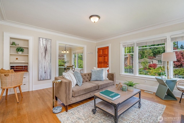 515 N 122nd St, Seattle, WA 98133 - living room featuring ornamental molding, light wood-style flooring, a chandelier, and built in shelves