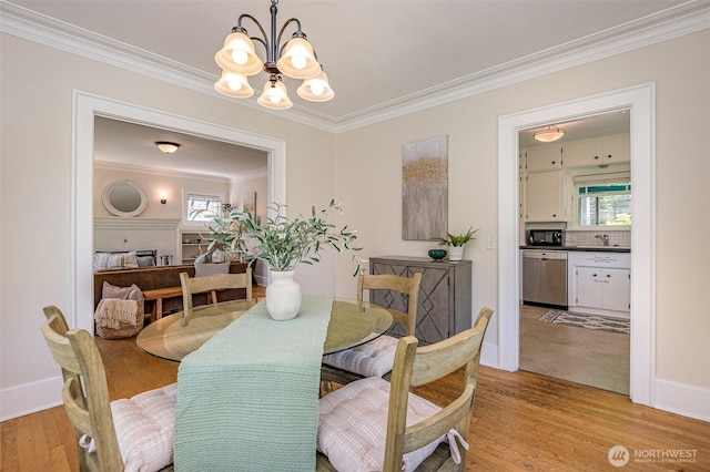 515 N 122nd St, Seattle, WA 98133 - dining room with light wood-style flooring, a chandelier, crown molding, and plenty of natural light