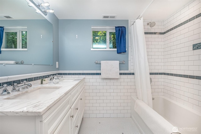 515 N 122nd St, Seattle, WA 98133 - full bathroom featuring tile walls, double vanity, shower / bath combo with shower curtain, tile patterned flooring, and wainscoting