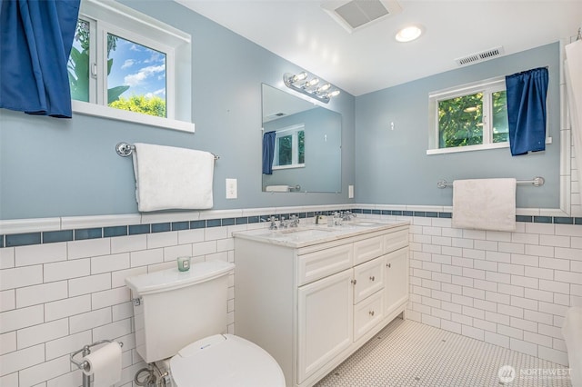 515 N 122nd St, Seattle, WA 98133 - bathroom featuring tile walls, double vanity, a wainscoted wall, tile patterned flooring, and recessed lighting