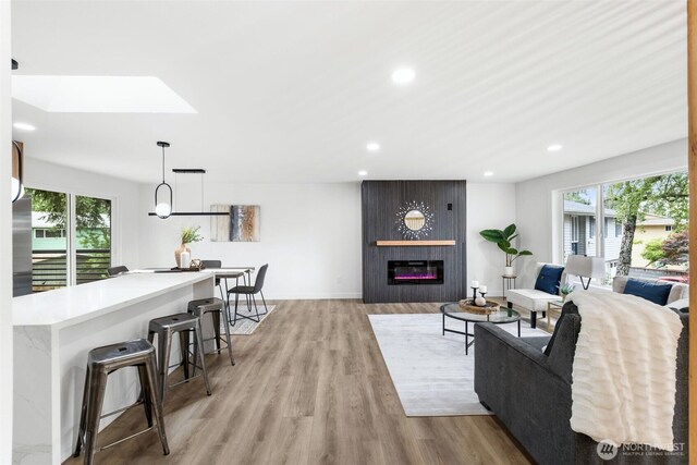 12816 SE 185th Pl, Renton, WA 98058 - living room featuring healthy amount of natural light, recessed lighting, light wood finished floors, a skylight, and a fireplace