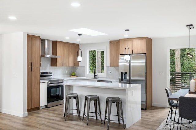 12816 SE 185th Pl, Renton, WA 98058 - kitchen with stainless steel appliances, wall chimney exhaust hood, a skylight, backsplash, and recessed lighting