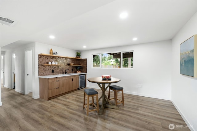 12816 SE 185th Pl, Renton, WA 98058 - indoor wet bar featuring wine cooler, light wood finished floors, recessed lighting, and decorative backsplash