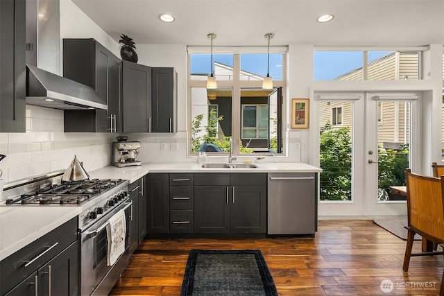 2808 14th Ave W Unit B, Seattle, WA 98119 - kitchen featuring wall chimney exhaust hood, appliances with stainless steel finishes, light countertops, tasteful backsplash, and recessed lighting