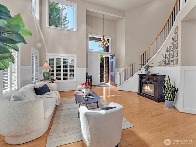 4021 220th St SE, Bothell, WA 98021 - living area featuring a towering ceiling, a chandelier, a decorative wall, wood finished floors, and healthy amount of natural light