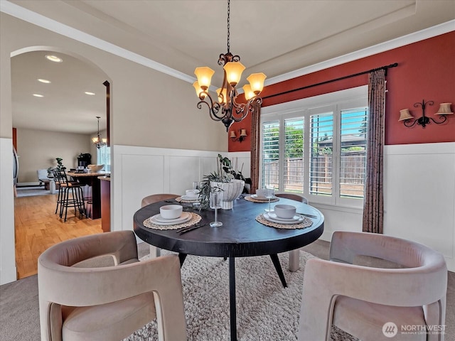4021 220th St SE, Bothell, WA 98021 - dining room with a chandelier, arched walkways, a wainscoted wall, crown molding, and wood finished floors