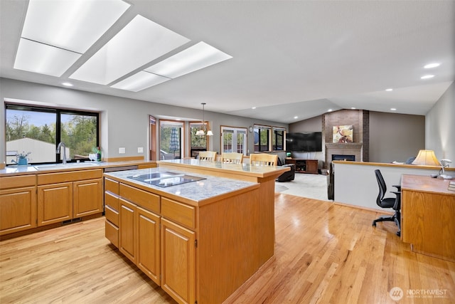 7617 160th St SE, Snohomish, WA 98296 - kitchen with a brick fireplace, a kitchen island, light countertops, light wood finished floors, and vaulted ceiling