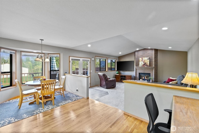7617 160th St SE, Snohomish, WA 98296 - dining room featuring wood finished floors, a fireplace, lofted ceiling, a textured ceiling, and recessed lighting