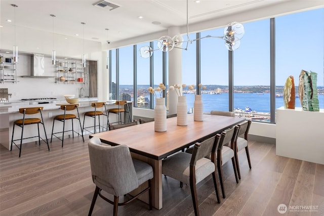 2510 6th Ave Unit 809, Seattle, WA 98121 - dining room featuring light wood-style floors, a chandelier, a water view, and recessed lighting