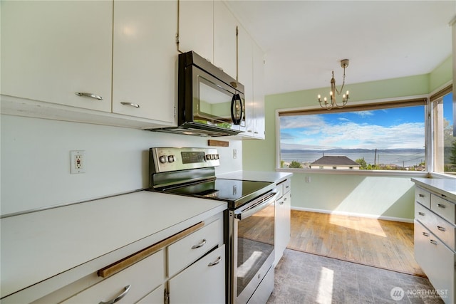 2602 Mccarver St, Tacoma, WA 98403 - kitchen featuring black microwave, stainless steel electric range oven, a chandelier, and plenty of natural light