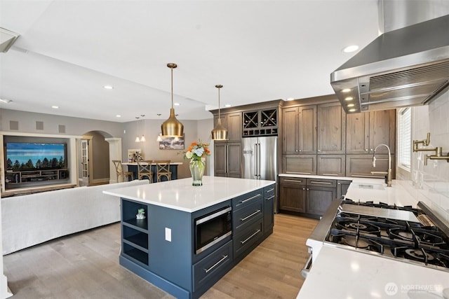 4706 NE 137th St NE, Vancouver, WA 98686 - kitchen featuring wall chimney exhaust hood, built in appliances, arched walkways, light countertops, and recessed lighting
