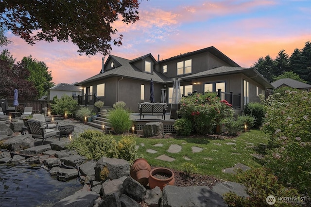 4706 NE 137th St NE, Vancouver, WA 98686 - back of house at dusk featuring an outdoor fire pit, a patio area, and stucco siding