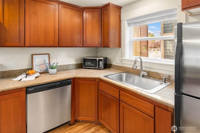 5235 11th Ave NE Unit A, Seattle, WA 98105 - kitchen featuring stainless steel appliances, light countertops, brown cabinets, and light wood finished floors